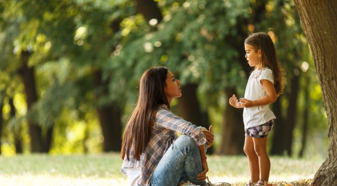 The Art of Parenting Mother holding her daughter and playing around the park on beaut